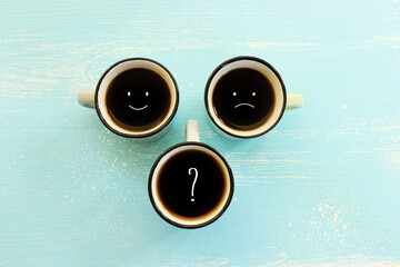 Wall Mural - unhappy and happy faces over coffee cups. concept of mindset and emotions
