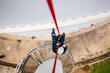 © chitsanupong - Focus top view male worker down height tank roof rope access safety inspection of thickness storage tank gas