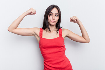 Young caucasian woman isolated on white background showing strength gesture with arms, symbol of feminine power