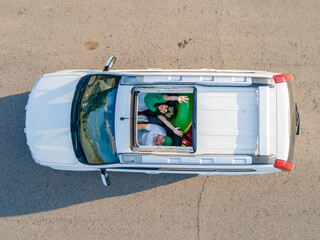 Wall Mural - happy couple in car overhead view car travel to sea concept