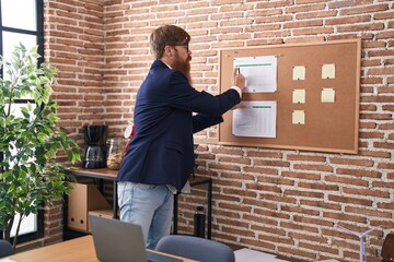 Canvas Print - Young redhead man business worker writing on cork board at office