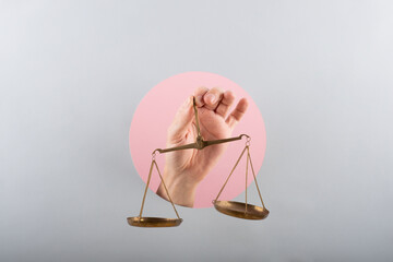 man hand holding a balance on pink and blue background