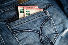 Two Of Ten Euro Banknotes Peek Out From Back Pocket Of Old Blue Jeans