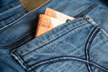 Two  Euro Banknotes Peek Out From Back Pocket Of Old Blue Jeans