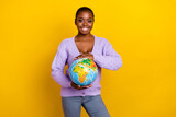 Photo of charming cheerful person arms hold planet earth globe toothy smile isolated on yellow color background