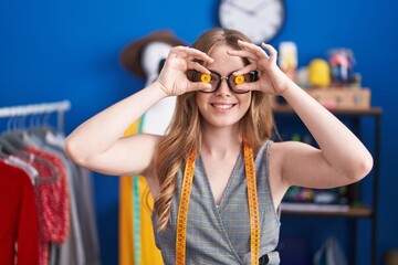 Sticker - Young woman tailor smiling confident holding buttons over eyes at clothing factory