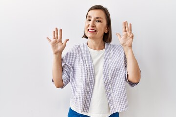 Canvas Print - Beautiful middle age hispanic woman standing over isolated background pointing with hand finger to the side showing advertisement, serious and calm face