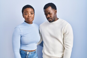 Poster - Young african american couple standing over blue background depressed and worry for distress, crying angry and afraid. sad expression.