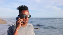 African American Man Talking On The Phone While Enjoying A Walk At The Beach In Southern California.