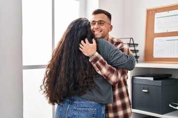 Poster - Man and woman business workers hugging each other at office