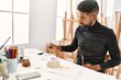 © Krakenimages.com - Young african american artist man concentrated painting pottery at art studio.