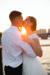 A kiss of the bride and groom at sunset. Wedding article. A happy couple. Love. Photos for printed products.