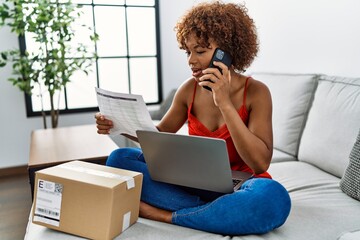 Sticker - Young african american woman having problem with order talking on the smartphone at home