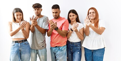 Poster - Group of young friends standing together over isolated background suffering pain on hands and fingers, arthritis inflammation