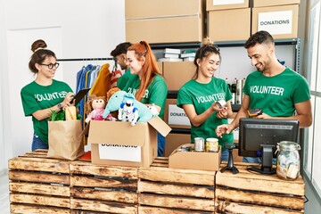 Group of young volunteers smiing happy working at charity center.