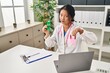 © Krakenimages.com - Young asian doctor woman holding support green ribbon with angry face, negative sign showing dislike with thumbs down, rejection concept