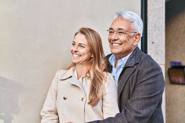 Sticker - Middle age man and woman couple hugging each other standing at street