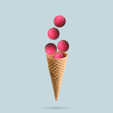 A Pink Tennis Balls Flies Out Of An Ice Cream Cone On Pastel Blue Background. Sports Concept. Tennis Concept.