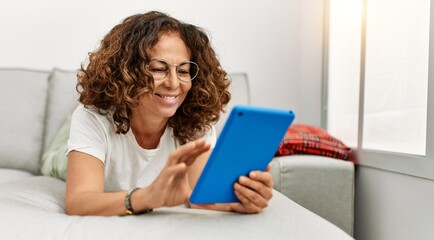 Poster - Middle age hispanic woman smiling confident using touchpad at home