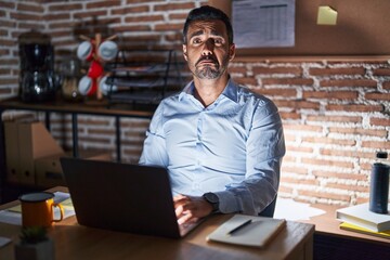 Poster - Hispanic man with beard working at the office at night depressed and worry for distress, crying angry and afraid. sad expression.