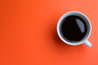 Leinwandbild Motiv White mug of freshly brewed hot coffee on orange background, top view. Space for text