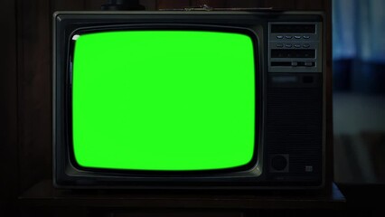 Wall Mural - old television set green screen in dark room. closeup. zoom out. you can replace green screen with t