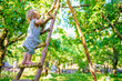 A brave child is not afraid of heights. Striving upward, growth and development. A little girl climbs a wooden ladder