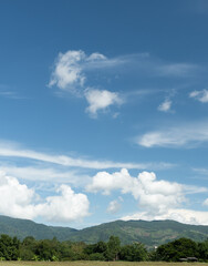 Wall Mural - the white clouds have a strange shape and moutain.the sky and the open space have mountains below.