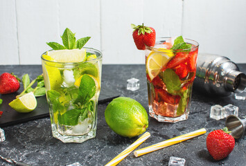 Wall Mural - Fresh Mojito cocktail set with lime, mint, strawberry and ice in glass on stone background. Steel bar tools.