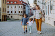 © Halfpoint - Young mother with zero waste shopping bag holding hands with her children and walking in city street street