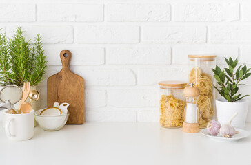 Set of pasta ingredients and kitchen utensils on white table