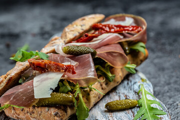 Wall Mural - prosciutto sandwich, Ciabatta with prosciutto, sun-dried tomatoes, gherkins, parmesan and arugula, banner, menu, recipe place for text