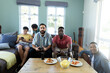 © wavebreak3 - Multiracial male friends with beer bottles and food on table playing video game on sofa at home