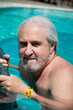 sexy grizzled man in miami pool. summer vacation in miami. man swim in miami resort