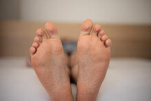 Caucasian Man's Bare Feet Laying On A Bed, Shallow Depth Of Field, Unrecognizable Face