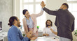 canvas print picture Group of happy people making deal and giving each other high five. Successful businessman and businesswoman greeting each other in informal casual business meeting in modern office. Teamwork concept