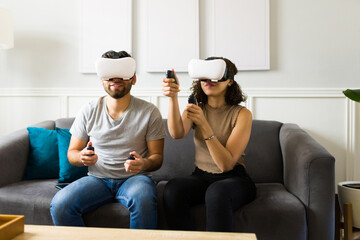 Young couple wearing virtual reality glasses and playing a video game