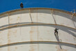 © chitsanupong - Male two worker down height tank roof rope access safety inspection thickness weld of storage tank gas