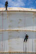 © chitsanupong - Male two worker down height tank roof rope access safety inspection thickness weld of storage tank gas