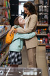 © LIGHTFIELD STUDIOS - happy girl with backpack embracing mother in stationery shop.