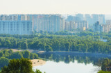 Fototapeta Miasto - Beautiful landscape photo of modern luxury residential district on embankment of the Dnieper River in Kyiv. Concept of modern architecture from glass, steel and concrete. High-rise houses at haze