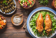 © dinasaeed - Arabic Cuisine; Egyptian traditional stuffed pigeon or 'Hamam Mahshi' dish. Served with green salad, oriental pickles, cooked Freekeh and stuffed vine leaves. Close up with copy space.