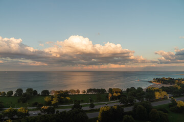 Wall Mural - a beautiful panoramic aerial view of lake michigan with fluffy white and yellow cumulus clouds in a 