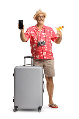Wall Mural - Mature male tourist with a suitcase holding a cocktail and showing a smartphone