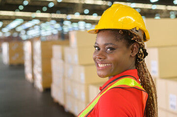 Portrait of young mixed race female worker wearing helmet in modern warehouse storage of retail shop