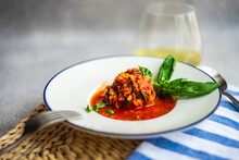 Bowl Of Meatballs In Tomato Sauce With A Glass Of White Wine