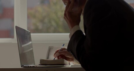 Poster - A man writes a text on paper while sitting at a table. He accumulates information before the meeting. The work of the operational department of criminologists. Departure to the place of the event.