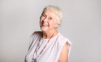 smiling retired senior woman looking at camera isolated on white background