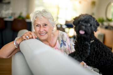 cute senior woman with poodle on the living room