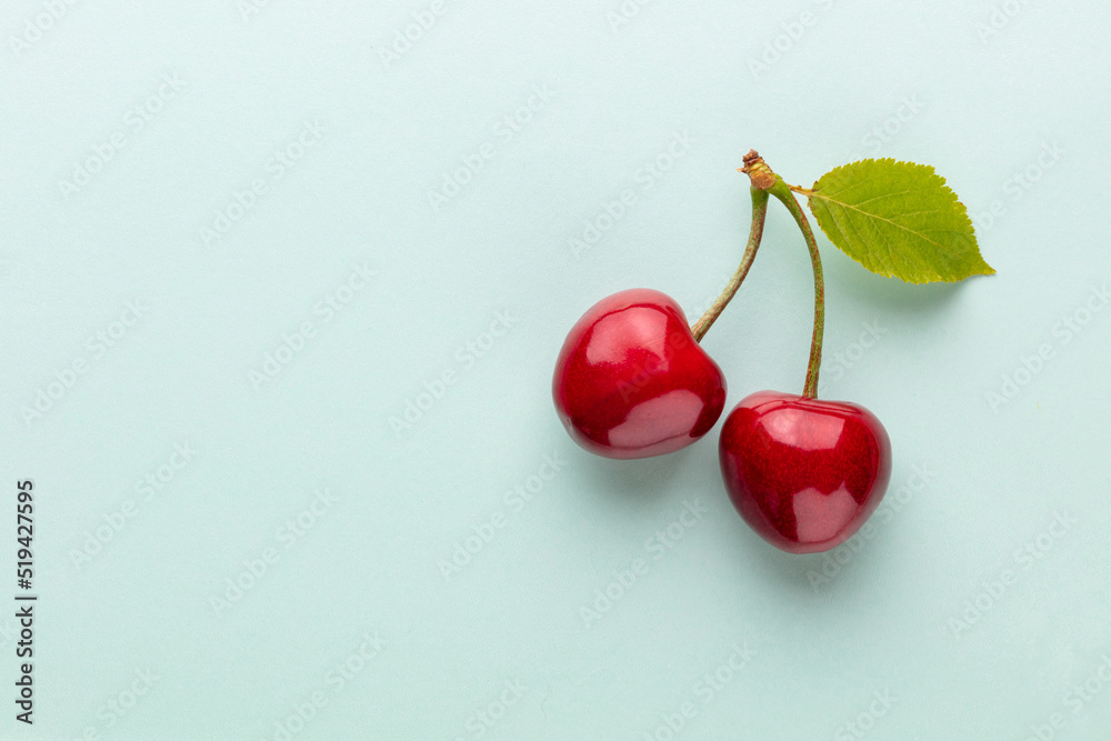Cherry berries on a pastel background top view.  Background with a cherry on a sprig, flat lay